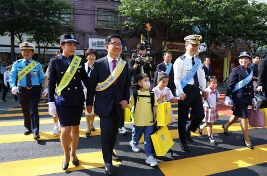 문헌일 구청장이 어린이와 노란색 횡단보도를 건너고 있다.(앞줄 왼쪽에서 두 번째)