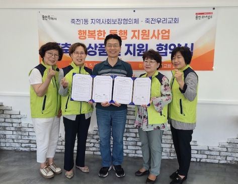 죽전1동 지역사회보장협의체 위원들이 죽전우리교회 관계자와 기념촬영을 하고 있다