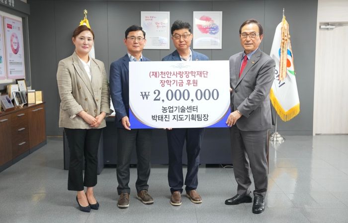 천안농업기술센터 박태진 팀장이 천안사랑장학재단에 후원금 200만원을 전달하고 기념 촬영을 하고 있다.