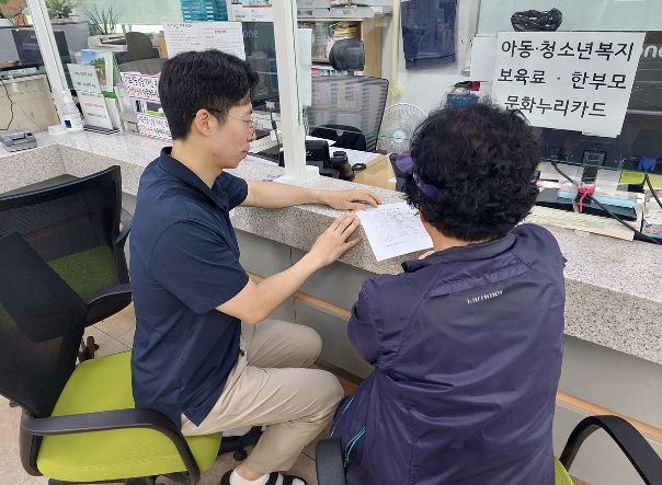 도봉구민이 동주민센터 직원의 도움을 받아 위기가구 발견 신고서를 작성하고 있다