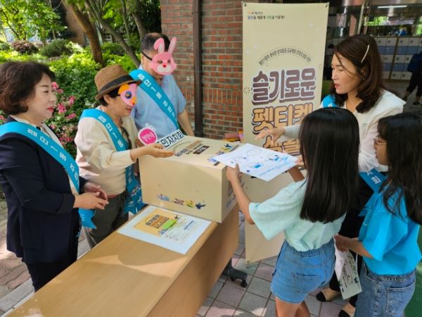 첨단1동의 한 초등학교 학생들이 ‘슬기로운 펫티켓’ 공모전 수거함에 포스터를 그린 도화지를 넣는 모습.