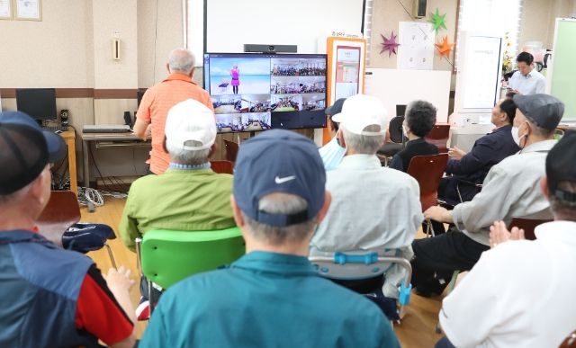 보라매경로당에 모인 어르신들이 화상플랫폼을 활용한 멧돌체조교실에 참여하고 있다.