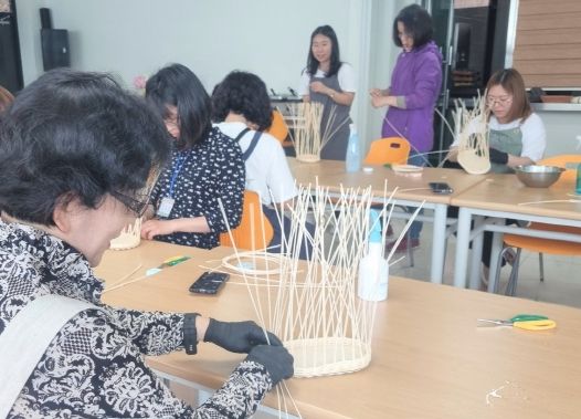 지난 5월 25일 라탄공예체험을 교육하고 있다.