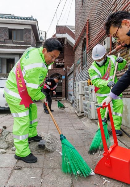 깨끗한 도시환경 조성을 위해 골목길 청소 중인 박강수 구청장(왼쪽)