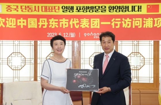 김남일 포항부시장이 12일 포항시청에서 장리홍 중국 단동시 인민정치협상회의 부주석에게 포항을 상징하는 기념품을 전달하고 있다.