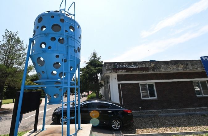 수원시 권선구 수원탑동시민농장 입구에 위치한 푸른지대창작샘터 건물 외부 전경