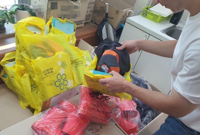 장안구 율천동 행정복지센터 공무원이 재활용품 수집 어르신에게 지급할 안전용품을 정리하고 있다.